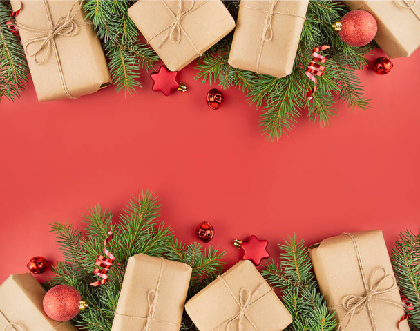 Joulun runko on valmistettu lahjapakkauksista, punaisista palloista, käärmeestä punaisella taustalla. Juhlallisia joulukoristeita. Joulutausta. Bannerin pohjapiirros, postikortti. Asunto valehteli. Kopioi tila - Valokuva, kuva