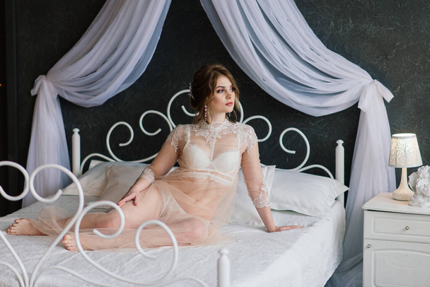 Hermosa chica sexy morena en ropa interior blanca posando en una habitación en el estudio interior - Foto, Imagen