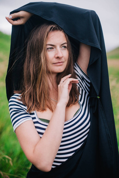 Beautiful girl in a black long skirt and striped T-shirt walks in green hole - Fotografie, Obrázek