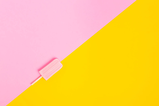 Růžová zmrzlina na tyčince na jasně růžovo-žlutém pozadí. Ležel. Místo pro textovku. Koncept léta - Fotografie, Obrázek