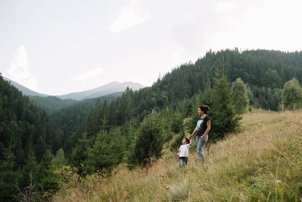 Young mom with baby boy travelling. Mother on hiking adventure with child, family trip in mountains. National Park. Hike with children. Active summer holidays. Fisheye lens - 写真・画像