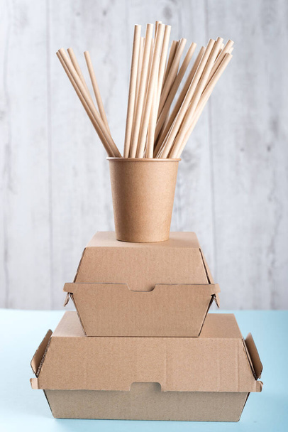A cup with drinking straws standing on two burger boxes - Photo, Image