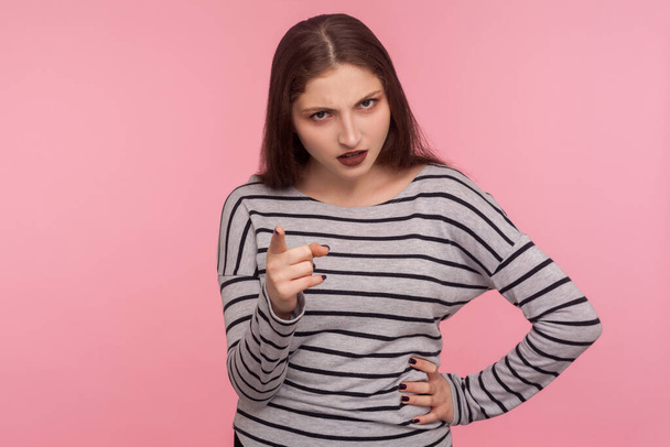 Be careful, I'm warning! Portrait of strict bossy brunette woman in striped sweatshirt giving advice, scolding with negative admonishing gesture. indoor studio shot isolated on pink background - Foto, imagen