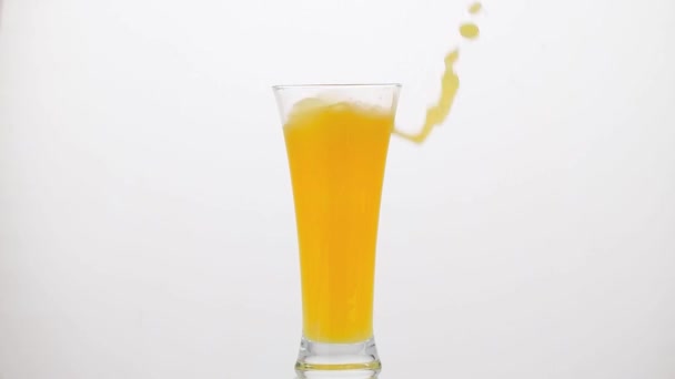 Ледяной куб, падающий на апельсиновый сок - Кадры, видео
