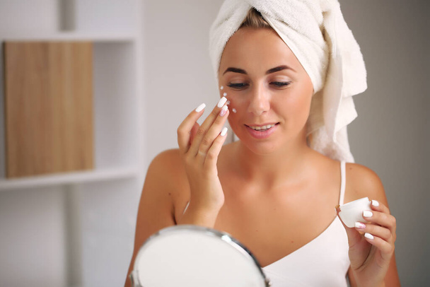 applying moisturizer on the face. girls with flawless skin - Fotó, kép