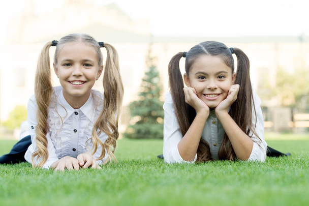 Beauty is whatever gives joy. Happy kids relax on green grass. Beauty look of little girls. Childs skincare products. Beauty salon. Beauty cosmetics. Summer vacation. School holidays. Feel beautiful - Photo, image