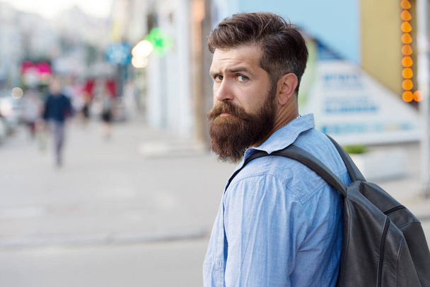 Backpack for urban traveling. Hipster backpack urban street background. Tourism and backpacking. Vacation concept. Modern rest. Bearded man travel. Guy exploring city. Discover local showplace - Foto, afbeelding