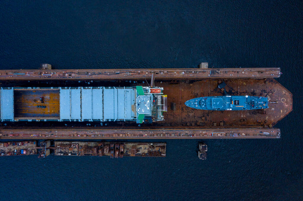 Riga, Latvia. July 20, 2020. Aerial view of the military ship being repaired in dry docks. Beautiful aerial industrial view of the ship. - Foto, immagini