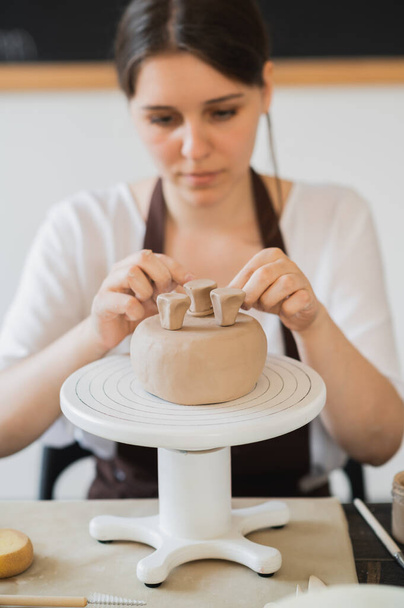Woman decorating handmade pottery vase close-up - Фото, изображение
