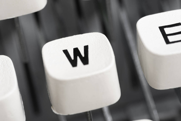 Een extreem close-up of macro-shot van een plastic toetsenborddop van een manuele schrijfmachine met ondiepe scherptediepte en selectieve scherpstelling. - Foto, afbeelding