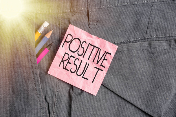Text sign showing Positive Result. Conceptual photo shows that an individual has the disease, condition, or biomarker Writing equipment and pink note paper inside pocket of man work trousers. - Photo, Image