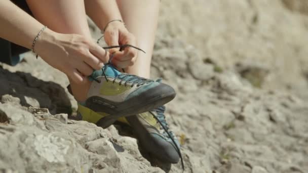 SULJE Up: tunnistamaton nainen sitoo hänen kiipeilykengät ennen kiipeily lohkare - Materiaali, video