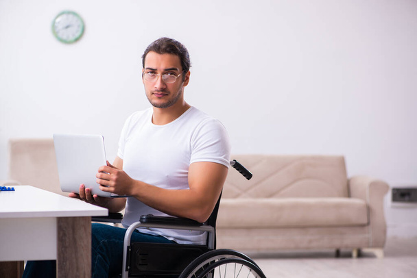 Jeune homme handicapé travaillant à la maison - Photo, image
