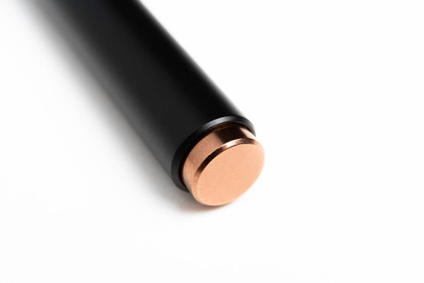 Uno scatto macro della porzione retrattile del clicker metallico di una penna a sfera nera moderna, elegante e snella. - Foto, immagini
