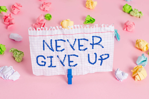 Conceptual hand writing showing Never Give Up. Business photo showcasing be persistent to keep on trying to improve the condition Colored crumpled papers empty reminder pink floor clothespin. - Fotoğraf, Görsel