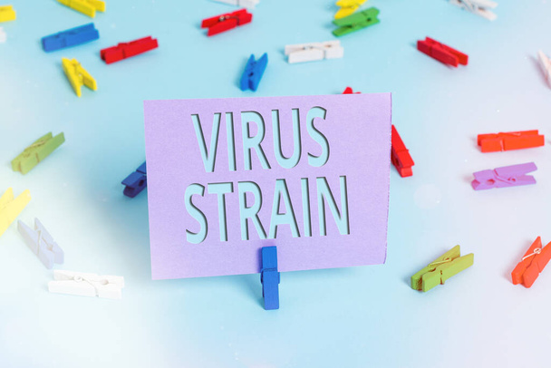 Handwriting text writing Virus Strain. Concept meaning Another genetic variant derived from the original microorganism Colored clothespin papers empty reminder blue floor background office pin. - Photo, Image