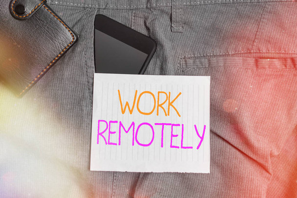 Conceptual hand writing showing Work Remotely. Business photo text fresh working style where employees handles job away from the public Smartphone device inside trousers front pocket with wallet. - Photo, Image
