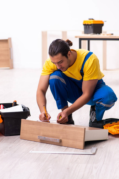 Jeune charpentier masculin travaillant à l'intérieur - Photo, image