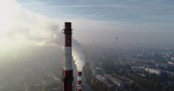 Inquinamento atmosferico in città. Vista aerea dello smog sulla città al mattino, camini fumatori dello stabilimento CHP e degli edifici della città - Breslavia, Polonia - Filmati, video