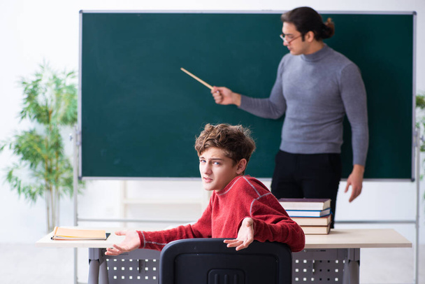 Молодий вчитель чоловічої статі і школяр в класі
 - Фото, зображення