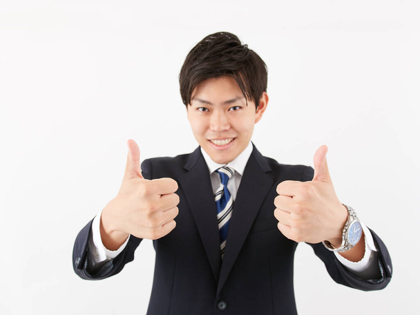 Japanse mannelijke zakenman geeft een goed teken - Foto, afbeelding
