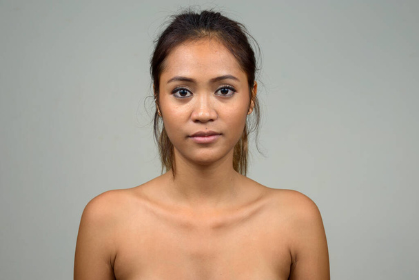 Estudio toma de joven hermosa mujer asiática sin camisa como concepto de salud y belleza contra fondo blanco - Foto, Imagen
