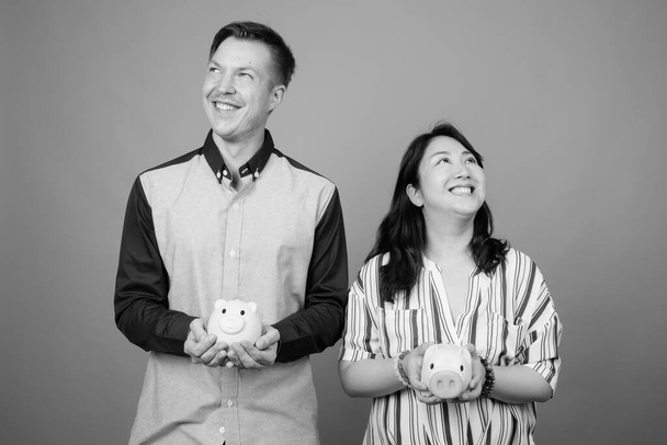 Jovem empresário e maduro japonês empresária juntos contra fundo cinza em preto e branco - Foto, Imagem