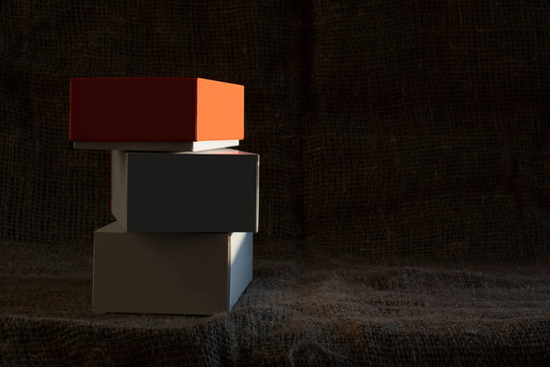 Small packing boxes on a dark burlap background - Fotó, kép