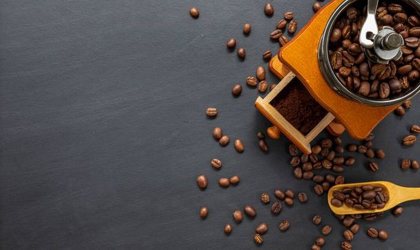 coffee bean and hand grinder on black table background. space for text. top view - Foto, Imagen