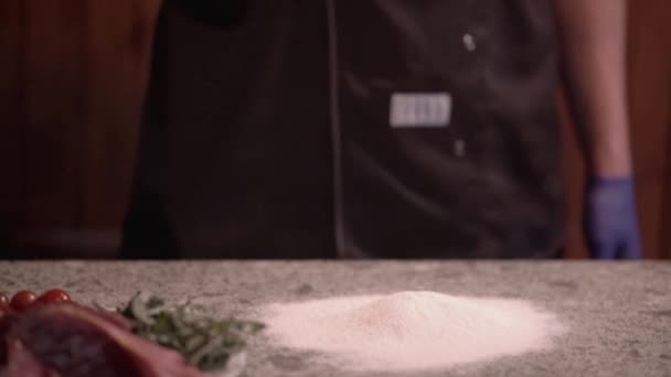 Szef kuchni w pizzerii rzuca na stół kawałek ciasta z pizzy, zwolniony ruch - Materiał filmowy, wideo