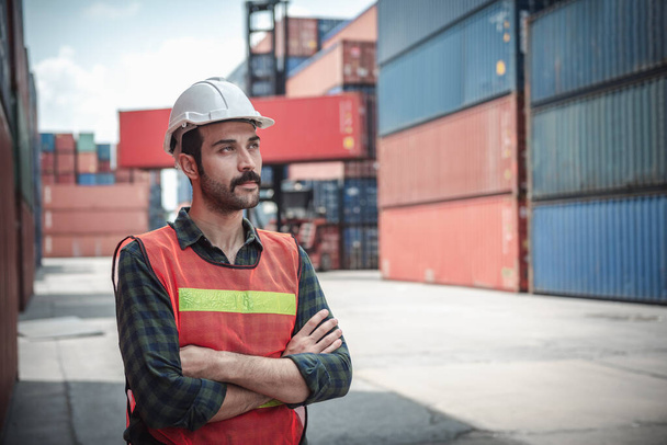 Portrét jistého dopravního inženýra v bezpečnostním vybavení stojícího v kontejnerovém loděnici. Doprava Strojírenství Management a kontejnery Logistika průmysl, lodní dělníci Zaměstnání - Fotografie, Obrázek