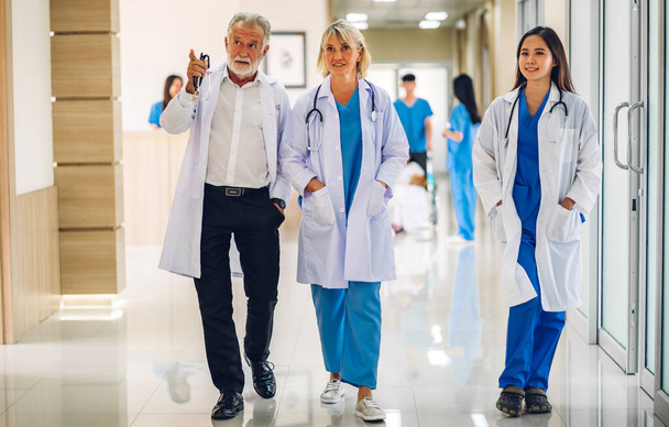 Grupo de profesionales del equipo médico con estetoscopio en uniforme de trabajo discutir y hablar caminando en el concepto de atención médica hospital.health - Foto, Imagen