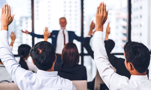 Podnikatel stojící před skupinou lidí v poradenských konferenčních seminářích a ukazující ruku v ruce s odpovědí na otázky v sále nebo na semináři. - Fotografie, Obrázek
