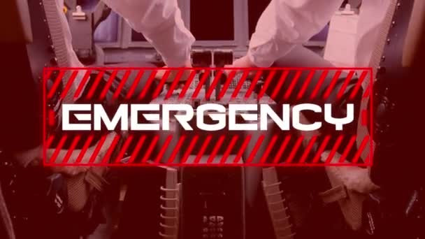 Animation of a red sign with white word Emergency with a rear mid section view of two male pilots flying airplane, in the background. Coronavirus Covid-19 pandemic concept digital composite. - Кадри, відео