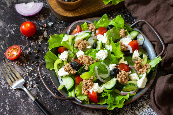 Здоровий літній обід. Грецький салат з консервованим тунцем, овочами та салатом на кам "яному стільнику.. - Фото, зображення
