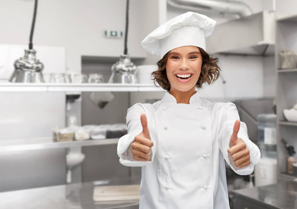 smiling female chef in toque showing thumbs up - Valokuva, kuva