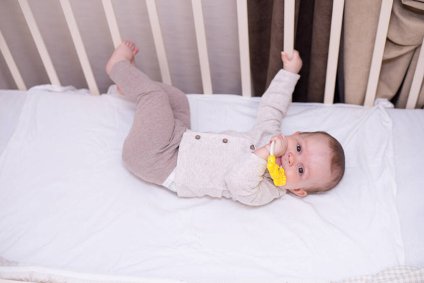 Cute baby playing with toy in bed . New born child, little girl having fun, . Family, childhood concept. copy space - Foto, Bild