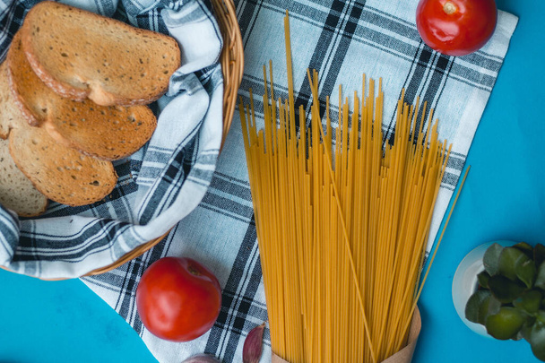Organická a čerstvá rajčata, těstoviny a česnek opečený chléb v košíku italská jídla koření suché oregáno - Fotografie, Obrázek