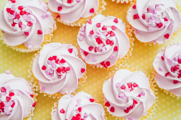 Cupcakes with pink cream and heart sprinkles - Fotoğraf, Görsel