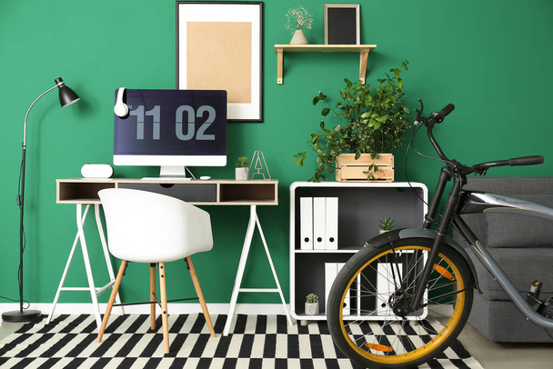 Стильний інтер'єр кімнати з робочим місцем і велосипедом
 - Фото, зображення