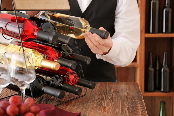 Sommelier választott üveg bort a pincében - Fotó, kép