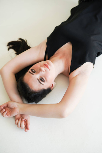 Sensual woman portrait laying on white background in black underwear - Fotoğraf, Görsel