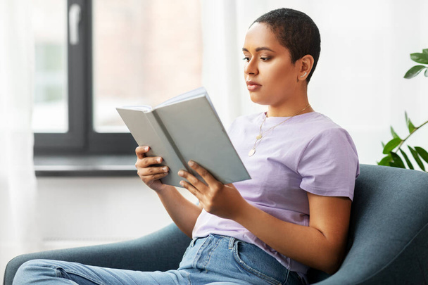 Африканская американка читает дома книги - Фото, изображение