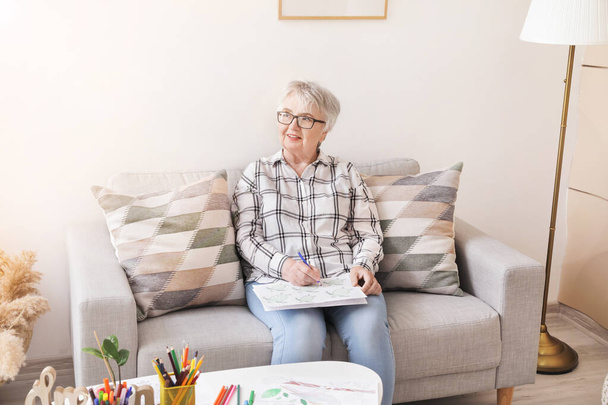 Senior woman coloring picture at home - Foto, Bild