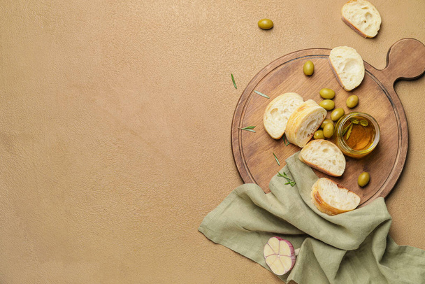 Potje lekkere olijfolie en brood op kleur achtergrond - Foto, afbeelding