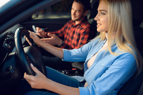 Female student and male instructor in car, driving school. Man teaching a woman to drive vehicle. Drivers license education - Φωτογραφία, εικόνα