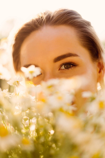 Beautiful woman with chamomile flowers - Фото, изображение