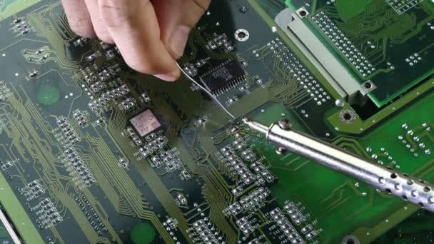 Los técnicos están utilizando un soldador para reparar electrónica de la tecnología de concepto de placa de circuito informático de hardware de circuito informático. - Metraje, vídeo