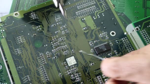 技術者は、コンピュータ回路基板の概念技術の電子を修復するためにハンダ付け鉄を使用していますコンピュータ回路ハードウェア. - 映像、動画