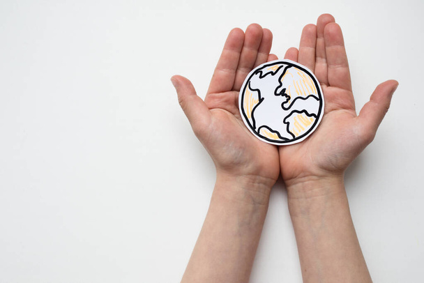 Hand holding a globe on a white - Zdjęcie, obraz